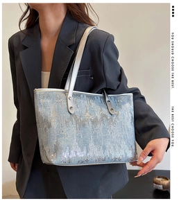 Detailed view of silver and light blue sequined tote bag worn over the shoulder