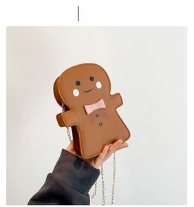 Detail of gingerbread man crossbody bag in brown PU leather with pink bow and gold chain