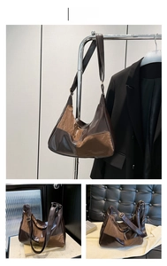 Detail view of large brown patchwork hobo bag with adjustable strap in urban setting