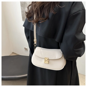 Detail of off-white lychee texture leather shoulder bag with gold metal clasp