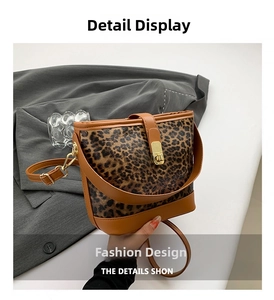 Detail of leopard print bucket bag with gold buckle and leather strap on a grey suit