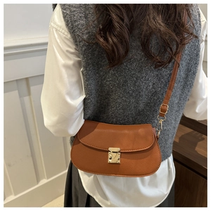 Detail of caramel leather crossbody bag with lychee texture and gold metal buckle
