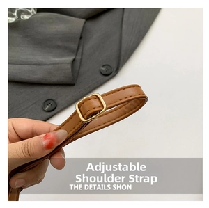 Detail of adjustable brown leather shoulder strap with golden metal buckle and fine stitching