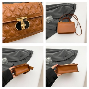 Detail of a brown quilted leather crossbody bag with T-shaped metal clasp and flap closure