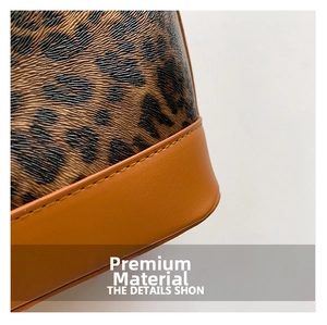 Close-up of leopard print texture and brown leather stitching on a bucket bag