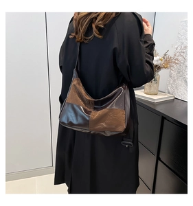 Detail view of the brown patchwork hobo bag made of glossy leather on a female model