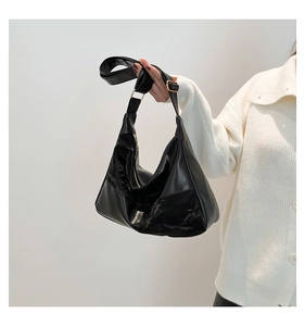 Close-up of black hobo bag showing stylish glossy and matte leather patchwork texture
