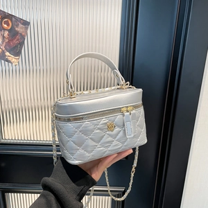 Quilted silver chain bucket bag with gold camellia floral ornament and top handle