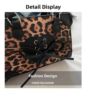 Detail of leopard print handbag featuring heart ornament and black leather bow accent
