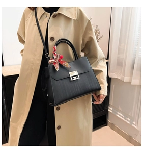 Dettaglio della borsa tote nera con fibbia quadrata d'argento e sciarpa decorativa