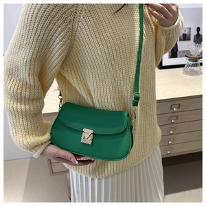Detail of bright green lychee texture crossbody bag with silver metal swivel lock