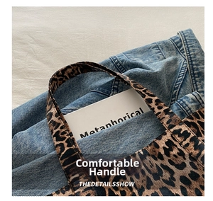 Detail of leopard print tote bag with thick handles showing canvas texture and daily use