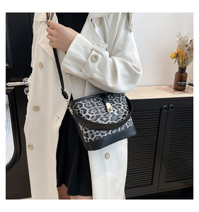 Detail of leopard print bucket bag with black leather strap and gold hardware accents