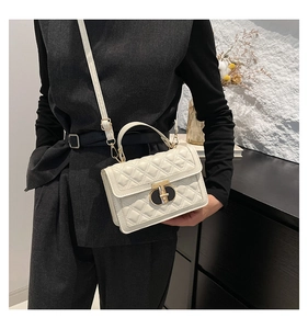 Detail of white quilted handbag with gold-tone twist lock and detachable strap