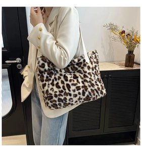 Detail view of plush leopard print tote bag with white leather strap on shoulder