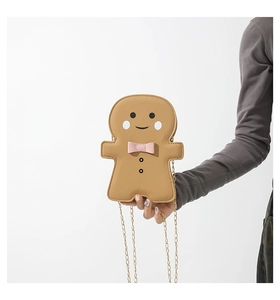 Detailed view of ginger man cross body bag with pink bow and golden chain strap