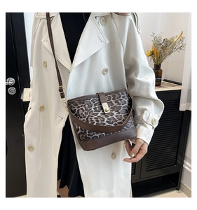 Detail of leopard print bucket bag featuring a gold twist lock and brown leather strap