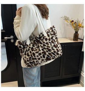 Detail of leopard print faux fur tote bag with long white leather shoulder strap