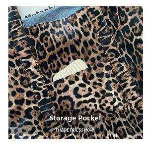 Detailed macro view of leopard print tote bag featuring a functional exterior storage pocket