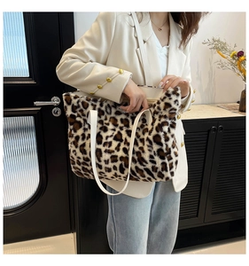 Close-up of leopard print faux fur tote bag with white handles for autumn fashion