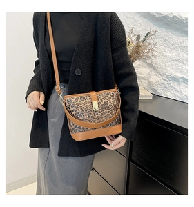 Detail of leopard print bucket bag with brown leather trim and gold metallic clasp