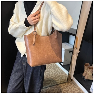 Dettaglio della borsa tote vintage in pelle marrone con scritte in rilievo
