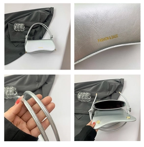 Detail view of metallic silver cracked leather underarm bag with gold logo and dual handles