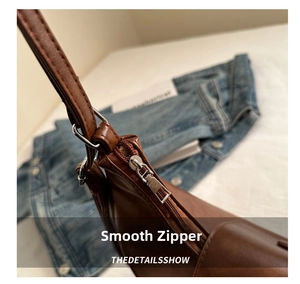 Detailed macro view of high-quality silver metal zipper on vintage brown leather tote bag