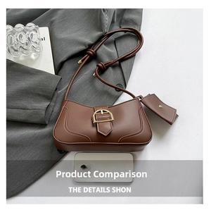 Detail of brown matte leather crescent bag with gold buckle and mini charm pouch