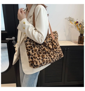 Chic leopard print faux fur tote bag featuring brown leather straps on a female model
