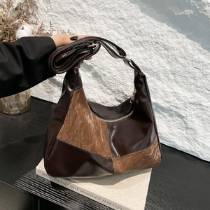Chic patchwork hobo bag in two-tone brown leather featuring a pleated texture and crescent shape