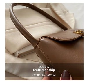 Detail of dark brown leather handbag featuring golden buckle and precise stitching