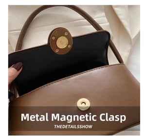Detailed view of the magnetic gold snap closure on a brown matte leather shoulder bag