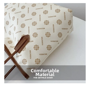 Detail of vintage flower print tote bag with lychee texture and reinforced brown handle
