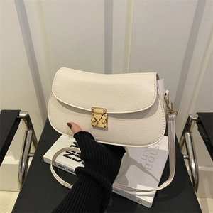 Minimalist beige lychee grain leather saddle bag with vintage gold metal clasp and thin strap