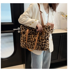 Detailed view of leopard print plush tote bag with brown leather handles and shoulder straps