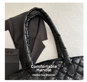 Détails des poignées rembourrées sur un grand sac cabas noir matelassé à losanges