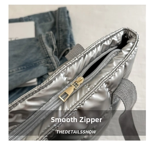 Detailed close-up of the smooth golden zipper on silver quilted tote bag for women