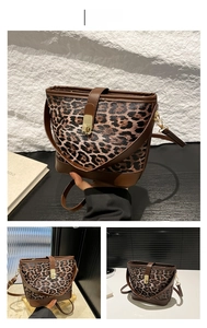 Detailed close-up of leopard print bucket bag with brown leather trim and gold metal clasp