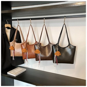 Detail view of four vintage tote bags in beige, brown, and black with plush dog charms