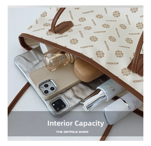 Top view of spacious tote bag interior holding smartphones, perfume, and skin care products