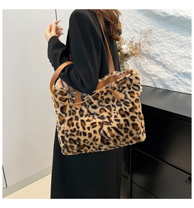 Detail of leopard print plush tote bag with brown leather straps worn on shoulder