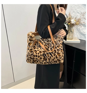 Detailed view of plush leopard print tote bag with brown leather shoulder straps