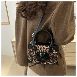 Detail of leopard print mini crossbody bag with heart lacing and black top handle