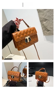 Detail of brown quilted leather bag featuring a two-tone metal lock and diamond stitching