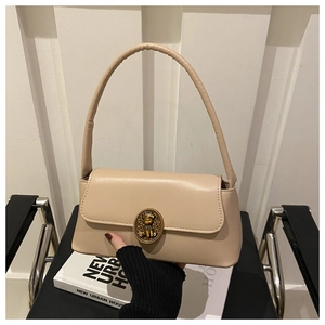 Detail of retro beige shoulder bag with vintage gold hardware and textured leather finish