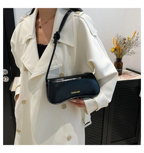 Bolso de hombro en charol negro brillante con letras doradas y detalle de nudo