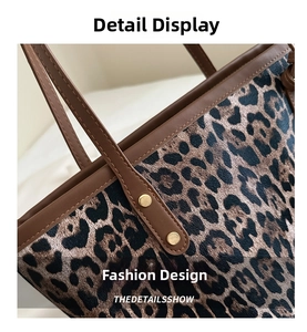 Close-up of leopard print tote bag featuring brown leather trim and golden rivets