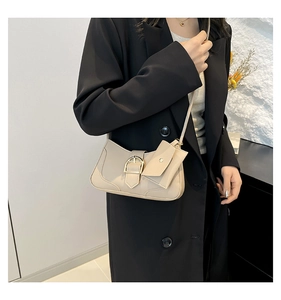Detail of minimalist crescent underarm bag in beige leather with metal buckle and small pouch