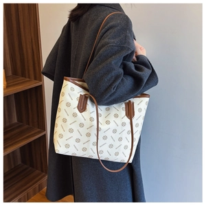 Large beige tote bag with brown handles and geometric print for daily commuting